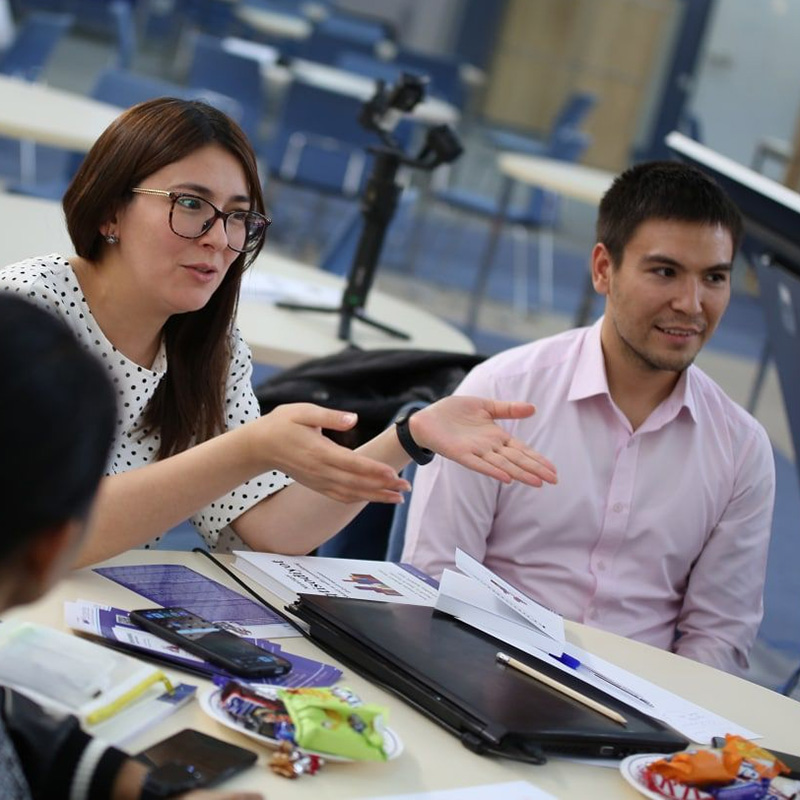 Two adults in a workshop, looking happy and engaging with others