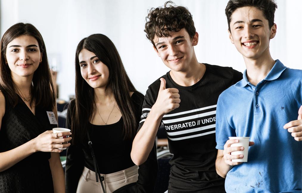 Four young students looking at the camera with positive facial expressions
